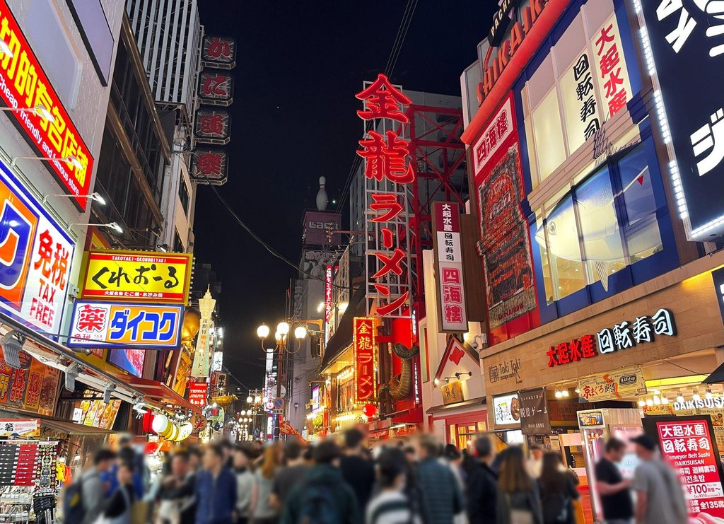 Parent using baby carrier in crowded Namba area