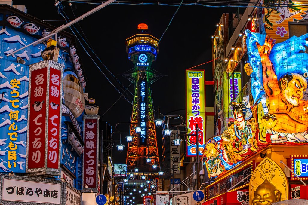 Shinsekai at night under neon lights with Tsutenkaku Tower