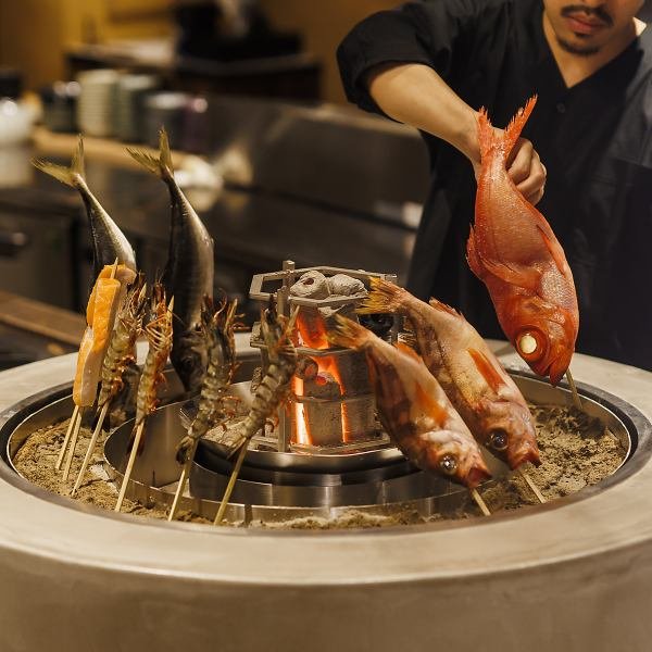 Seafood grilling over charcoal at Tottotto counter