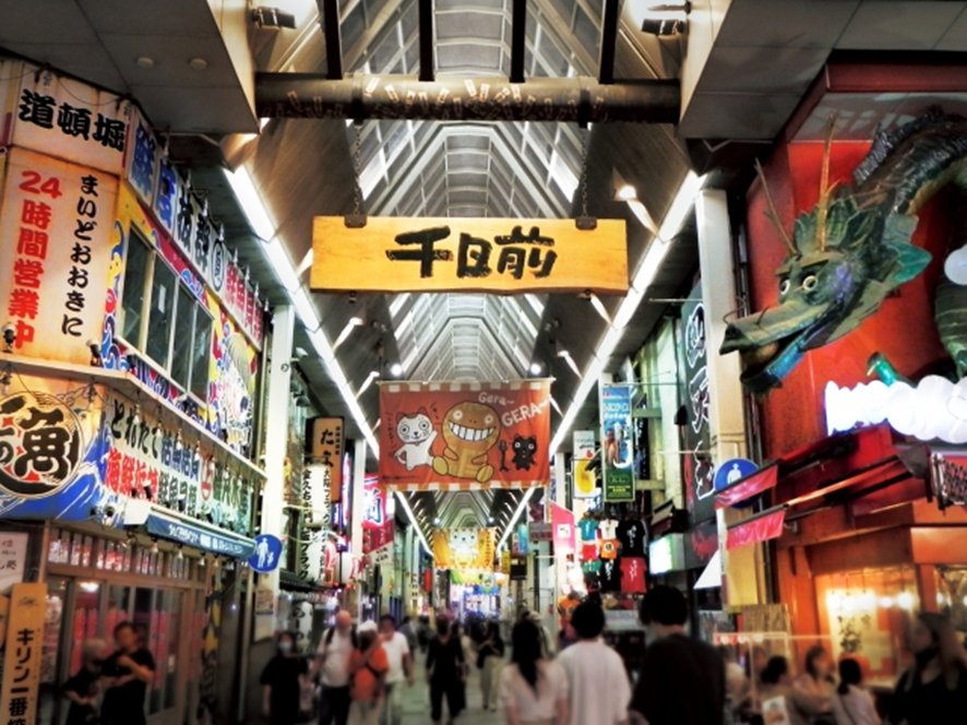 Bustling Namba izakaya scene with diners at night